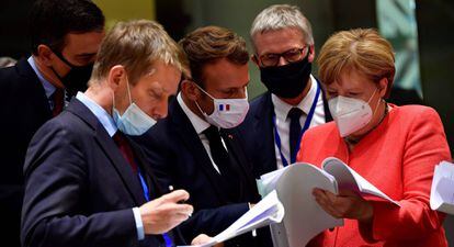 Na foto, o presidente do Governo espanhol, Pedro Sánchez (à esquerda), o presidente da França, Emmanuel Macron, e a chanceler alemã, Angela Merkel, examinam documentos durante a cúpula da UE em Bruxelas, nesta segunda-feira.