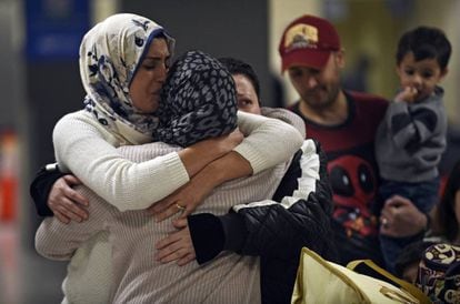 Uma família iraquiana recebe uma mulher que não podia viajar por conta do veto, no domingo no aeroporto de Dulles, Virgínia.