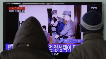 Dois sul-coreanos veem a notícia na televisão.