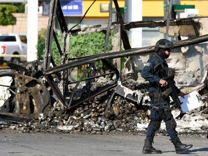 Um policial em frente a um veículo queimado nesta sexta-feira em Culiacán.