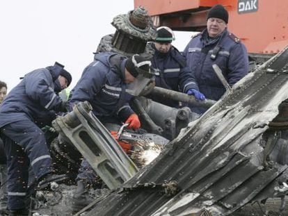 Trabalhadores retiram restos da fuselagem do avião em Grabovo.