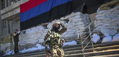 Um miliciano passa pela entrada de uma delegacia ocupada por ativistas pró-Rússia em Slaviansk.