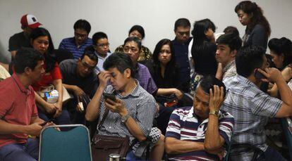 Familiares dos passageiros esperam notícias no aeroporto de Surabaya.