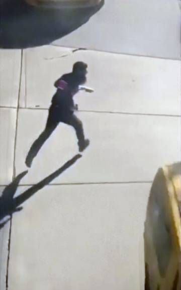Uma imagem do terrorista portando duas armas falsas e correndo pela rua depois de cometer o atentado e antes de ser preso.