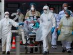 TOPSHOT - Medical staff carry a patient infected with the novel coronavirus (Covid-19) in an emergency vehicle at the Saint-Jean train station in Bordeaux, southwestern France, on April 3, 2020, after an evacuation on a medicalised TGV high-speed train from eastern France, on the eighteenth day of a lockdown in France aimed at curbing the spread of the COVID-19 infection caused by the novel coronavirus in France. (Photo by NICOLAS TUCAT / AFP)