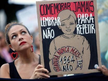Uma manifestante segura uma placa contra a comemoração do 55º aniversário do golpe militar, no Rio de Janeiro.