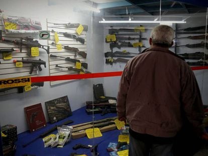 Homem observa vitrine com armas em São Paulo.