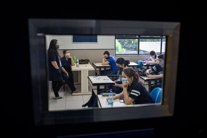 Usando máscaras de proteção e sentando em lugares marcados, estudantes assistem a uma aula no colégio particular Martha Falcão, em Manaus.