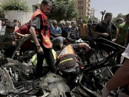 Palestinos inspecionam os restos do veículo do dirigente do Hamas Mohamed Ghoul, atingido neste domingo em um ataque contra Gaza.