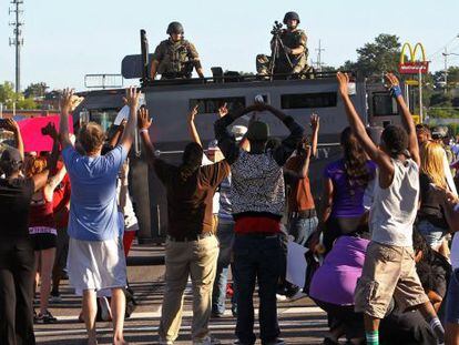 Manifestantes diante de um veículo blindado em Ferguson.