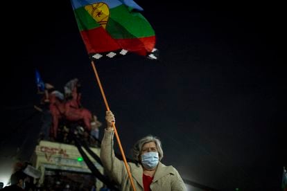 Mulher com a bandeira mapuche celebra a vitória do “aprovo” no plebiscito para a redação de uma nova Constituição no Chile.
