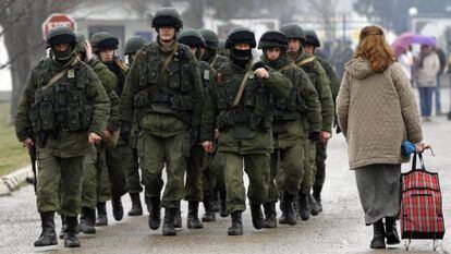 Homens uniformados junto a uma base militar em Perevalnoye.