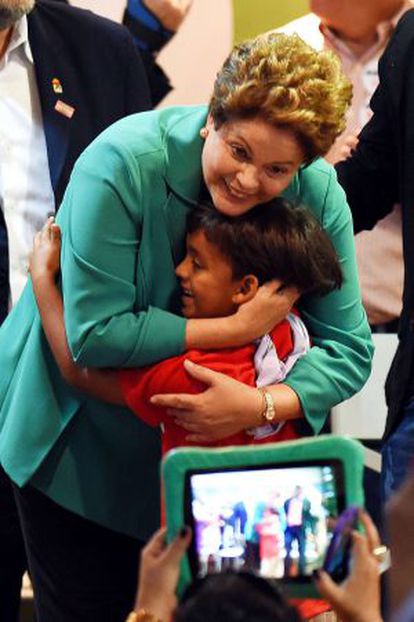 Dilma Rousseff abraça garoto em evento com trabalhadores rurais.