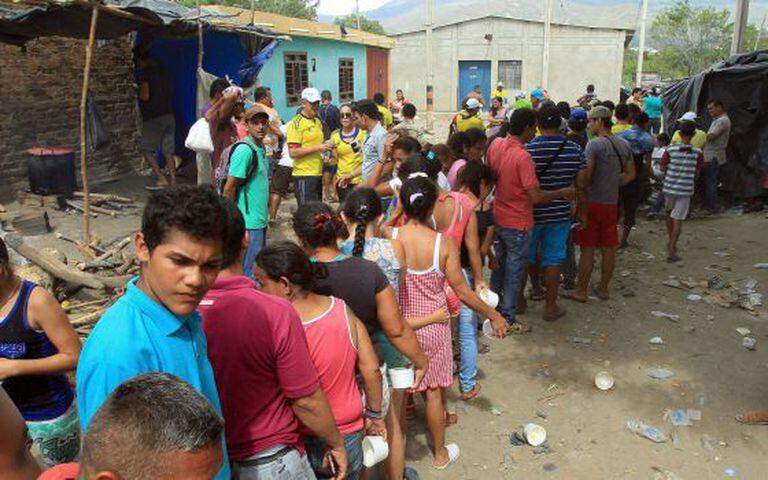 Moradores de Cúcuta dão comida a deportados da Venezuela.