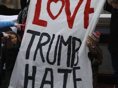 Manifestantes seguram o cartaz com o trocadilho &quot;Love Trumps Hate&quot; (O amor supera o &oacute;dio).