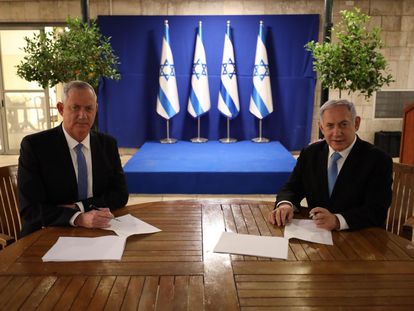 Netanyahu, à direita, assina com o centrista Beny Gantz o acordo alcançado nesta segunda-feira.