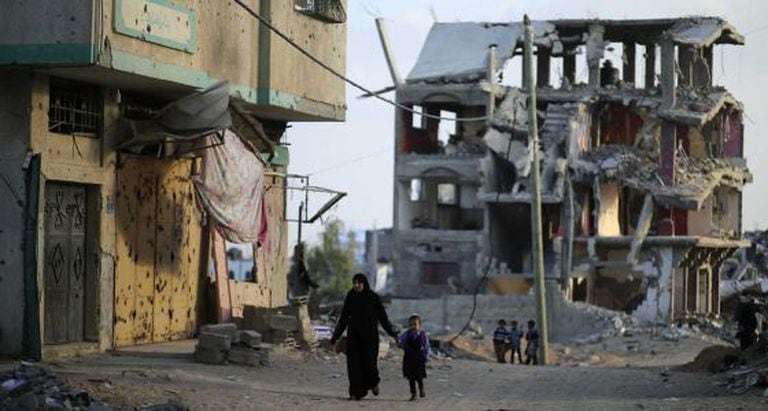 Uma mãe e seu filho, nas ruínas de Gaza.
