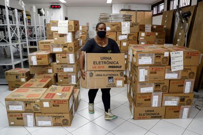 Funcionária do Tribunal Regional Eleitoral de São Paulo transporta urnas eletrônicas a um lugar de votação na capital paulista, no sábado, véspera do primeiro turno das eleições municipais 2020.