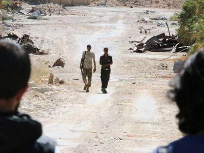 Rebeldes sírios patrulham a principal via de acesso a Alepo.