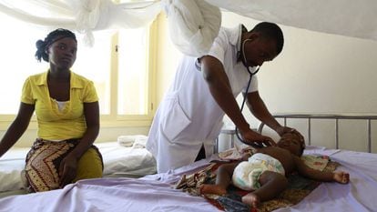 Um médico atende um bebê internado por malária em um hospital de Moçambique.