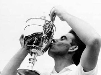Manolo Santana beija o troféu de Wimbledon que ganhou em 1966 contra o norte-americano Dennis Ralston.