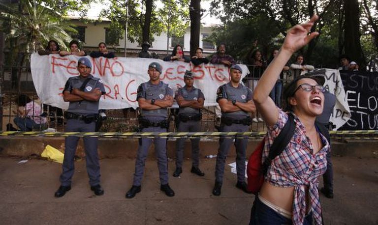 Estudantes protestam em frente à escola sitiada.