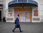 A man wearing a face mask walks past a boarded up restaurant near Piccadilly Circus in London's main high street  shopping area on May 22, 2020 as lockdown restrictions to combat the spread of the novel coronavirus remain in place. - UK retail sales dived by a record 18.1 percent in April with the country in coronavirus lockdown, triggering a surge in government borrowing to an unprecedented level, data showed on May 22. (Photo by DANIEL LEAL-OLIVAS / AFP)