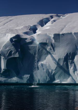 O gelo derrete com o aquecimento e forma uma cachoeira sobre o oceano na Antártica.