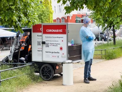 Um homem opera um laboratório ambulante para testes rápidos de covid-19, num parque de Berlim.