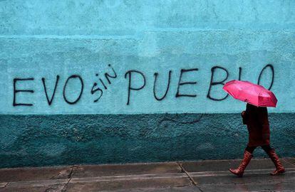 Mulher caminha por um muro em La Paz, Bolívia.