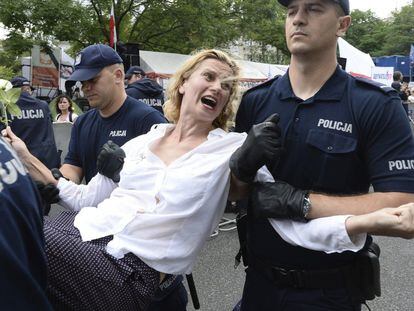 Policiais prendem manifestante em Varsóvia em protesto após o Parlamento aprovar lei para reformar o sistema judicia.