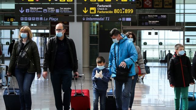 Crianças usam máscaras de proteção no aeroporto de Barcelona.