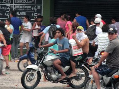 Um grupo de pessoas saqueia um supermercado nas periferias de Tucumán, no norte de Argentina.