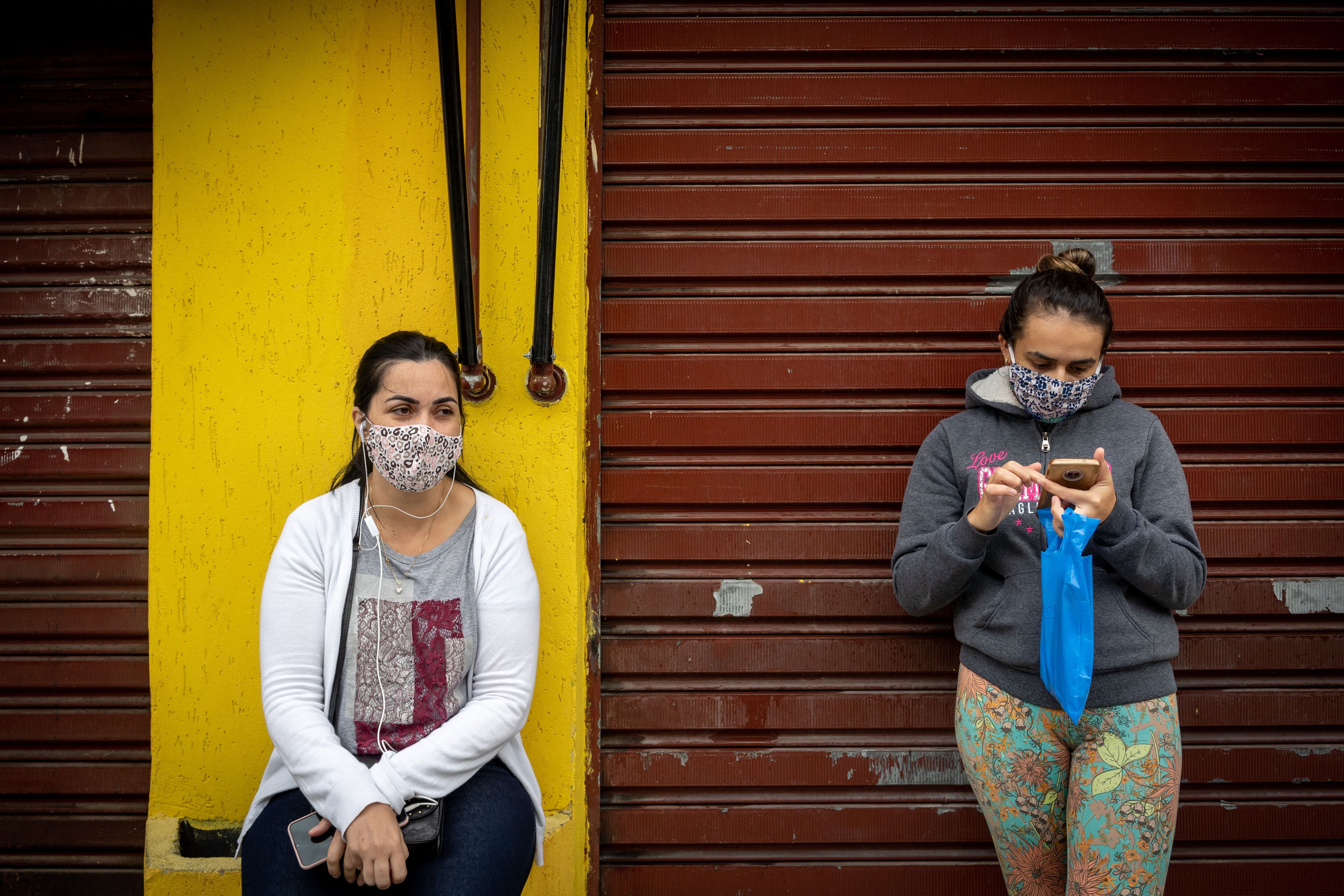 Ana Claudia e Paula esperam notícias dos maridos, que lutam contra a covid-19 em São Paulo. Há semanas elas vêm todos os dias à porta do Hospital Municipal Tide Setúbal, na zona leste, para ouvir o boletim dos pacientes, que não é passado por telefone.