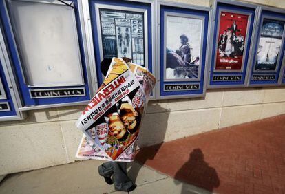 Funcionário retira cartazes de A Entrevista de um cinema em Atlanta.