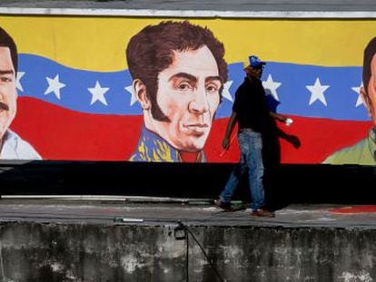 Um homem caminha diante de um mural na capital venezuelana.