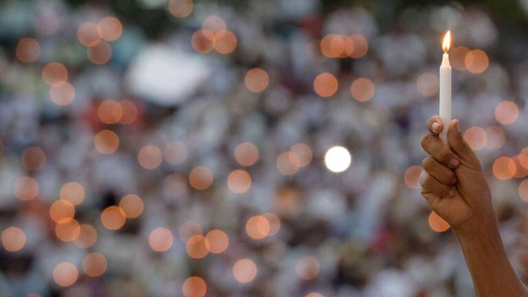 Fiel segura uma vela em uma cerimônia religiosa pela paz.