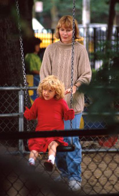 Mia Farrow brinca no parque com sua filha adotiva Dylan em 1990.
