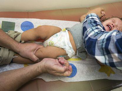 Pediatra administra vacina do sarampo em uma criança em Califórnia.