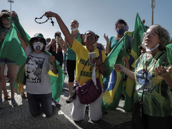 BRA02. RÍO DE JANEIRO (BRASIL), 21/06/2020.- Mujeres oran durante una manifestación de apoyo al presidente Jair Bolsonaro, este domingo, en la playa de Copacabana, en Río de Janeiro (Brasil). EFE/ Antonio Lacerda