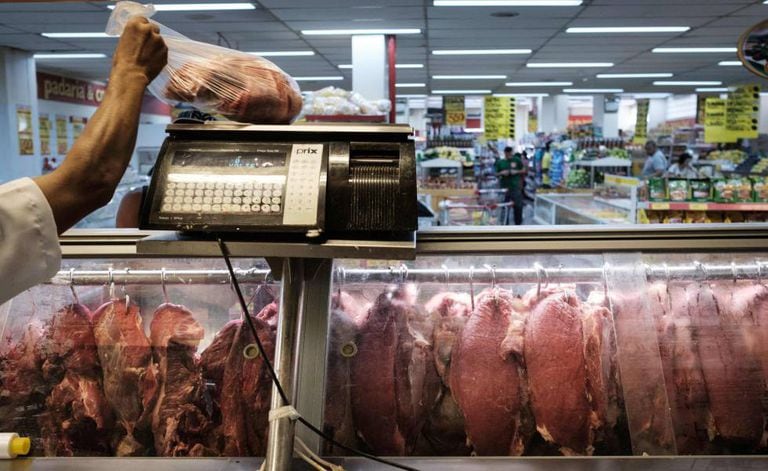 Funcionário pesa um pedaço de carne durante inspeção do Procon no Rio.