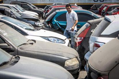 Consumidor analisa carros em pátio de leilão público em Guarulhos.