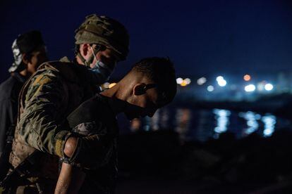 Soldado conduz imigrante que saía da água na praia de El Tarajal, em Ceuta.