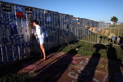 Uma mulher olha a través do muro instalado em Brasília.