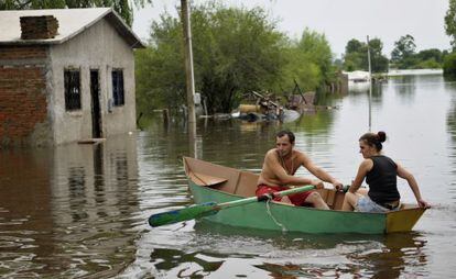 Um casal uruguaio rema um bote nas ruas inundadas de Durazno em 2010.