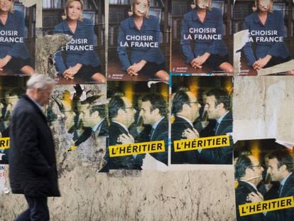 Um homem passeia em frente a cartazes com propaganda eleitoral na sexta-feira, em Paris.