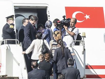 O primeiro-ministro turco, Ahmed Davutoglu (acima à esquerda), recebe os reféns libertados, em um avião em Sanliurfa.