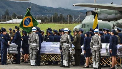 Militares colombianos preparam a partida de caixões das vítimas ao Brasil.