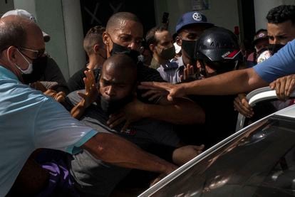 Vários policiais detêm um manifestante durante os protestos contra o Governo cubano na Havana, neste domingo.  