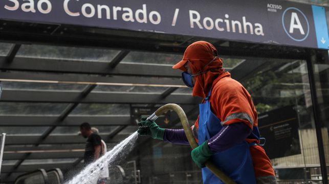 Funcionário limpa estação de metrô e ruas na Rocinha, no Rio.